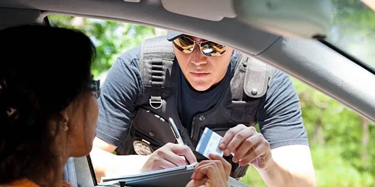 A woman receiving a ticket from a police officer.