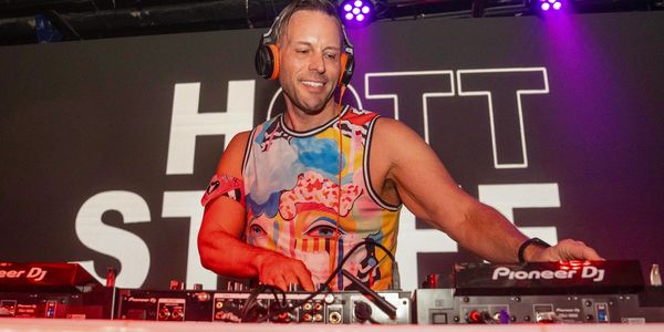 DJ performing with colorful shirt and headphones.