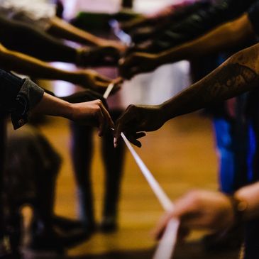 Group of people holding a string as part of a teambuilding exercise