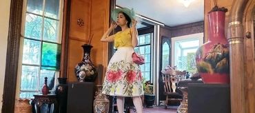 Woman in floral skirt and teal hat