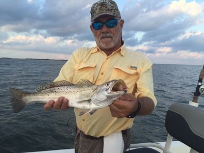 Man holding a fish on a boat.