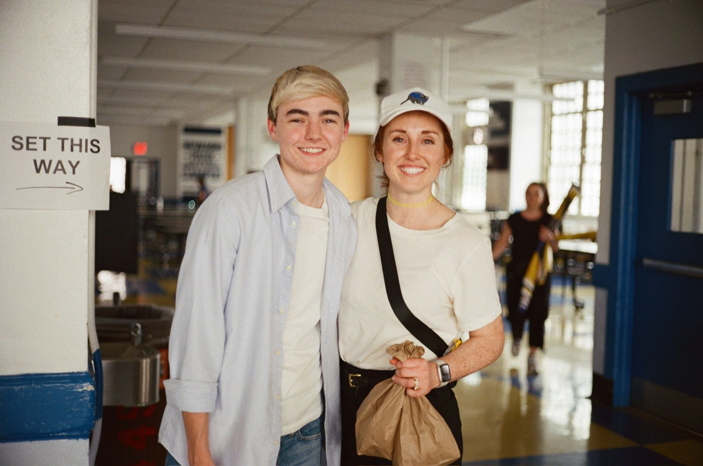 Two smiling people posing inside a building.