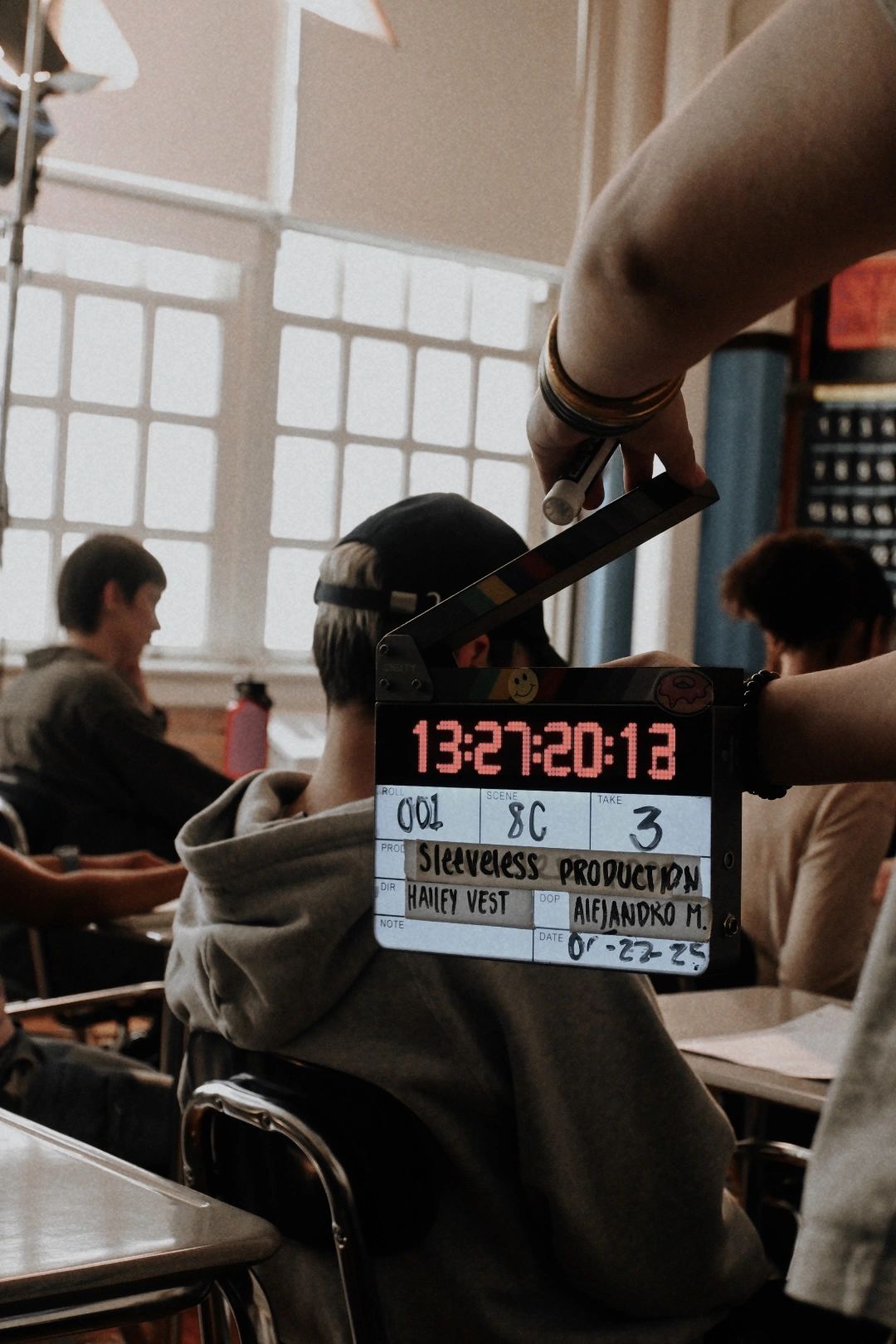 Film slate in front of students in a classroom setting.