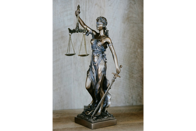 Bronze statue of Lady Justice holding scales and sword, blindfolded.