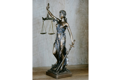 Bronze statue of Lady Justice holding scales and sword.
