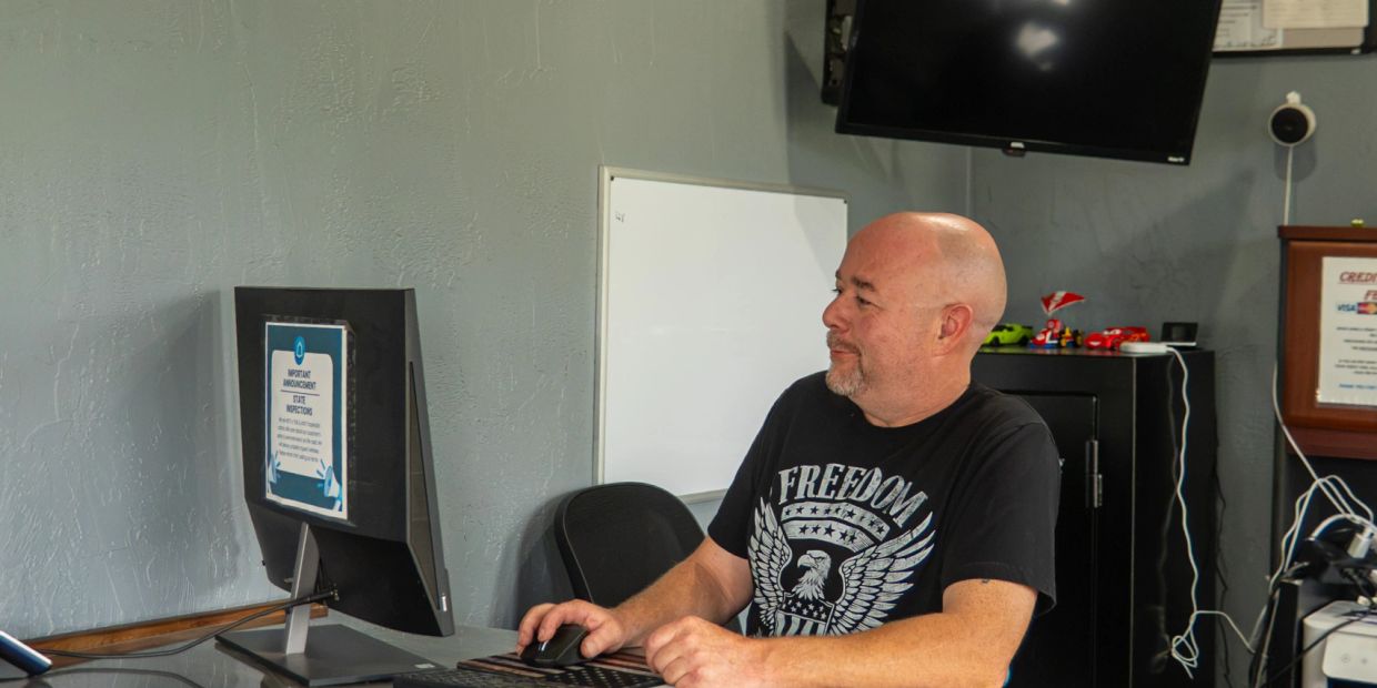 Man working on a computer in an office setting.