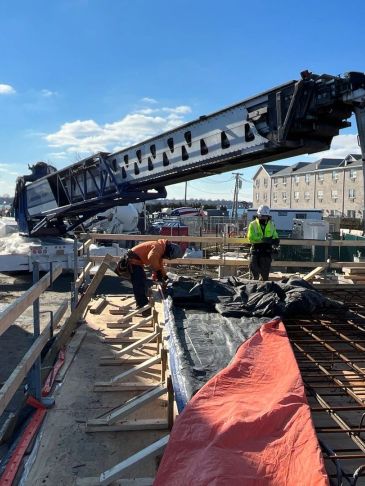 Construction workers working on a site with a crane.