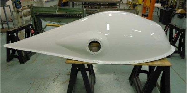 A large white aerodynamic structure in a workshop.