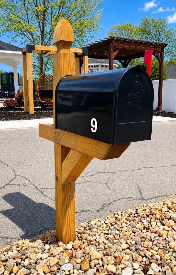 Black mailbox numbered 9 on a wooden post.