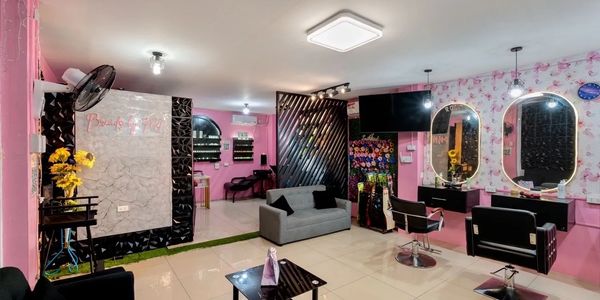 Bright pink beauty salon with modern styling chairs and mirrors.