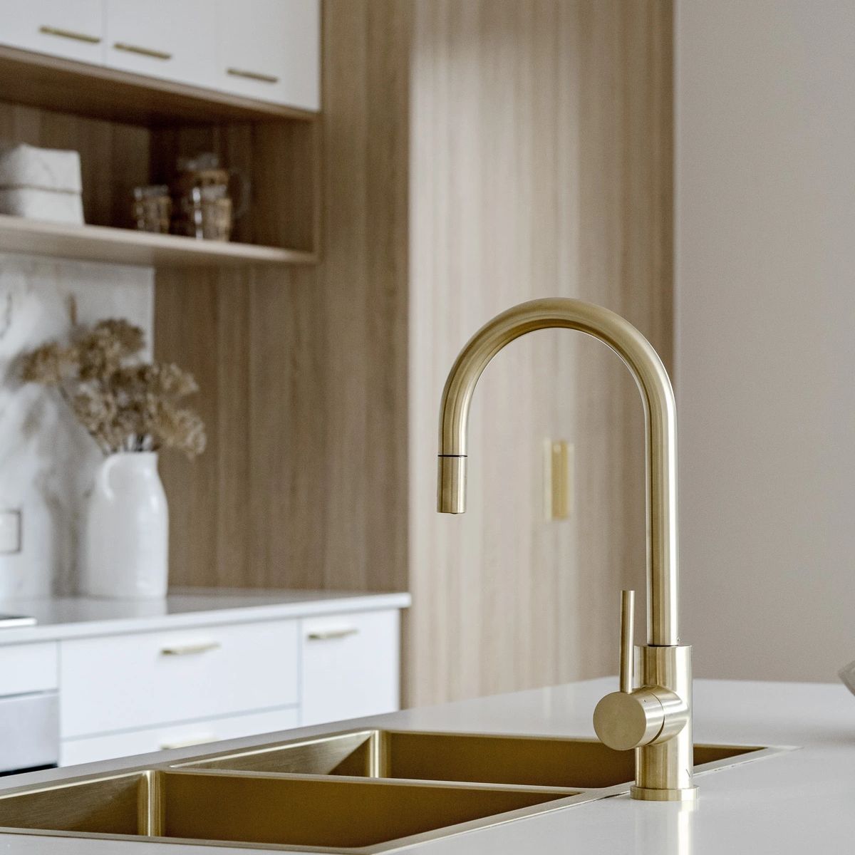 Stylish kitchen with white and timber cabinets and gold tapware.