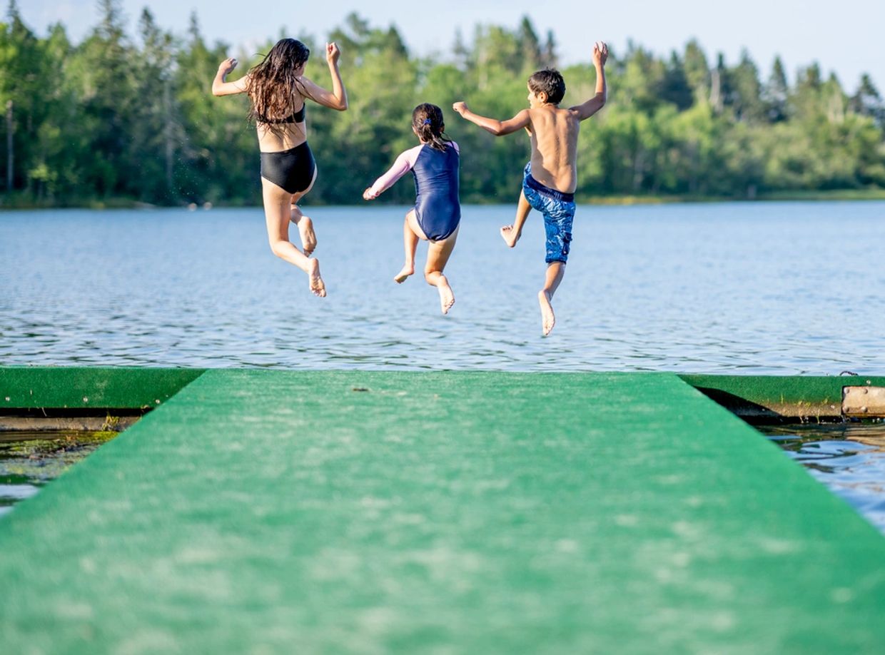 Kids jumping off a cottage dock.