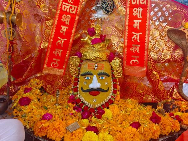 Decorated idol of Lord Mahakal with flowers and traditional accessories.