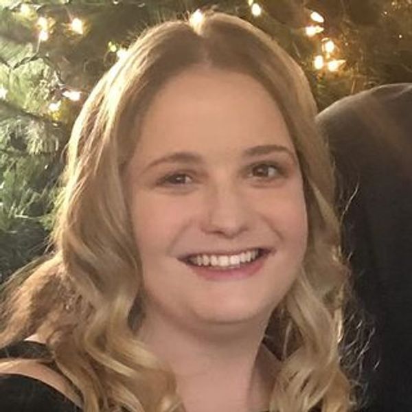 Smiling woman with curly blonde hair.