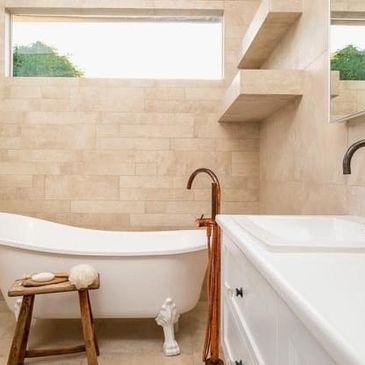 Elegant bathroom with a clawfoot tub, wooden stool, and modern fixtures.