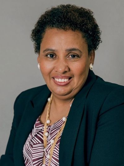 Professional woman smiling confidently in business attire.