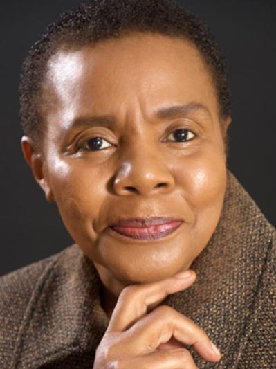 Close-up portrait of a thoughtful woman with short hair and a warm expression.