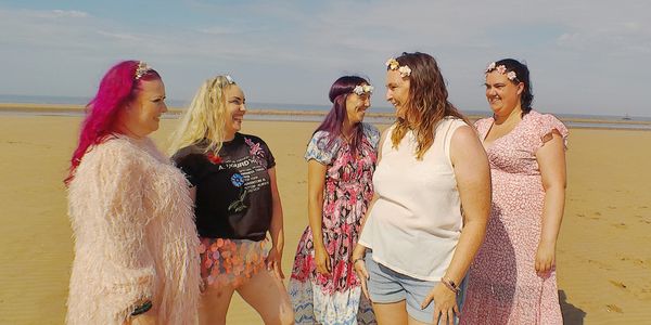 Women on a beach smiling as they heal after divorce