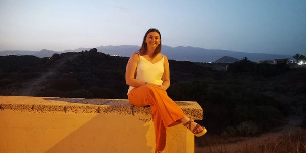 Woman sat on a wall smiling after divorce