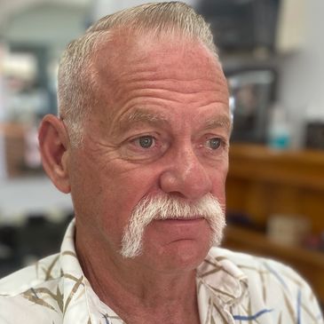 Classsic taper , comb over with handle bar mustache. 