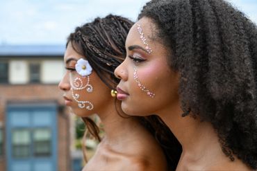 Two women with intricate face paint designs.