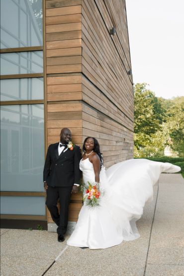 Happy bride and groom posing outside.