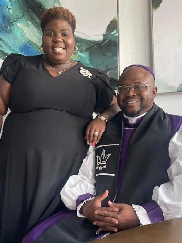 Smiling couple dressed in formal attire indoors.