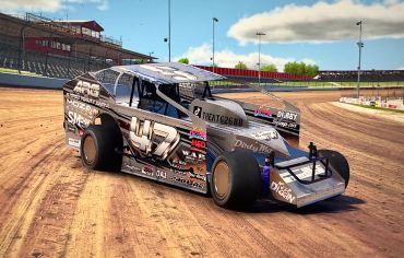 Modified dirt track race car on a dirt oval track under clear skies.
