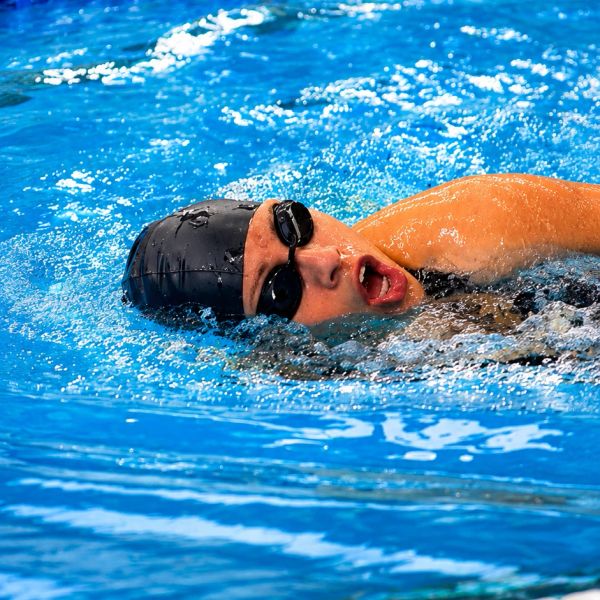 Nadador en una piscina con gorro y gafas.