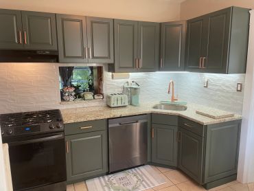 Modern kitchen with dark cabinets, granite countertops, and stainless steel appliances.