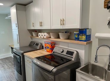Modern laundry room with washer, dryer, and utility sink.
