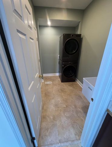 Compact laundry room with stacked washer and dryer units.