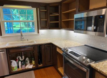 Kitchen corner with wooden cabinets, granite countertops, and stainless steel appliances.