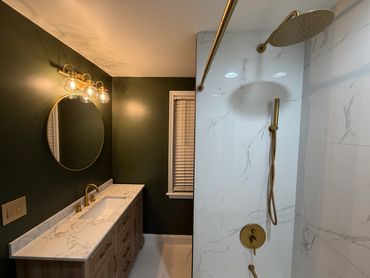 Modern bathroom with marble countertop and gold fixtures.