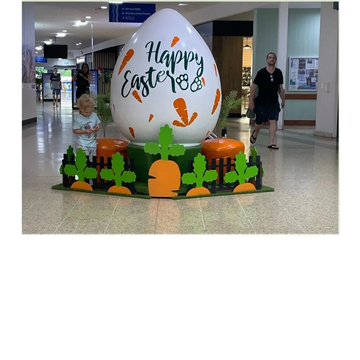 Large Easter egg display with children nearby.