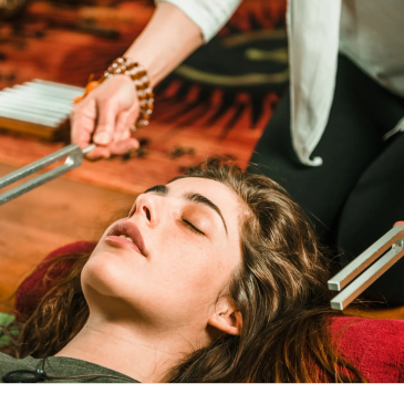 Person receiving sound therapy with tuning forks.