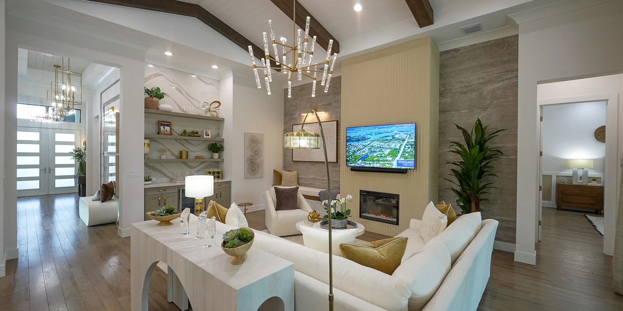Modern living room with high ceilings, wooden beams, and stylish lighting.
