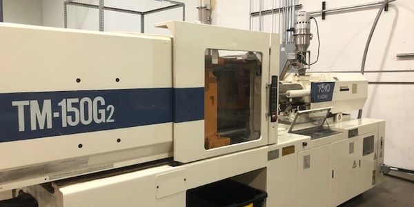 Industrial TM-150G2 injection molding machine in a factory setting.