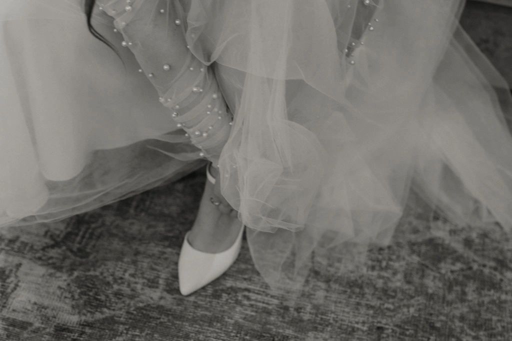Black and white photo of the bride putting on her shoes on. All-inclusive Corsicana wedding venue near Dallas TX