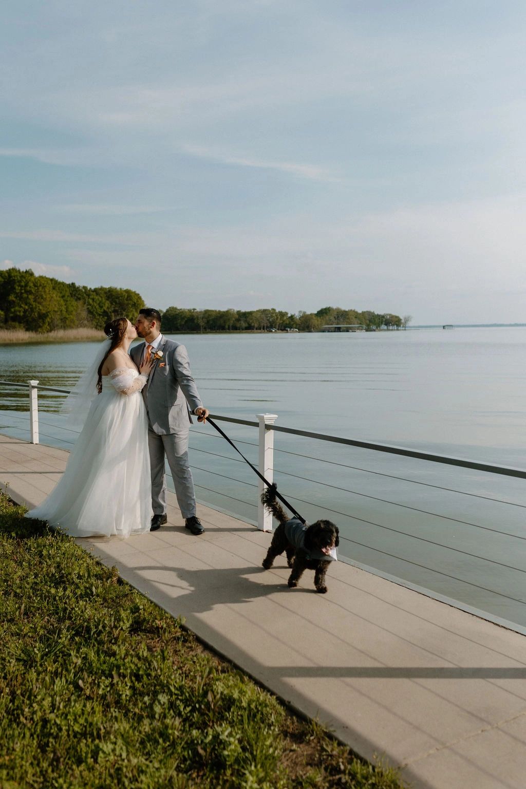 Lakefront pet friendly wedding venue in Dallas Texas, Wedding couple walking their dog by the lake.