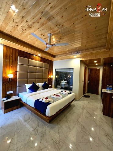 Elegant hotel room with wooden accents and a cozy bed setup.
