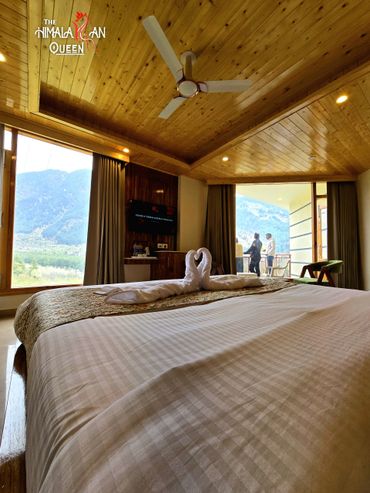 Cozy hotel room with mountain views and towel swans on the bed.