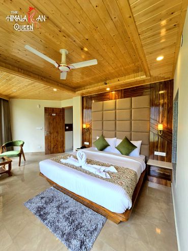 Elegant hotel room with wooden ceiling and cozy bed.