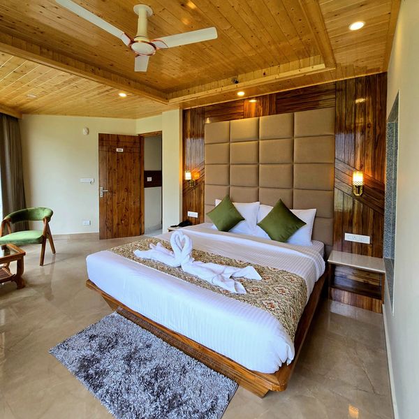 Cozy hotel room with wooden ceiling and elegant bed setup.