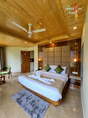Cozy hotel room with wooden ceiling and elegant bed setup.