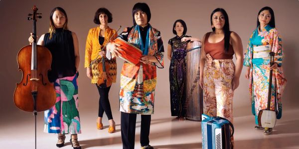 Six women with musical instruments, posing confidently.