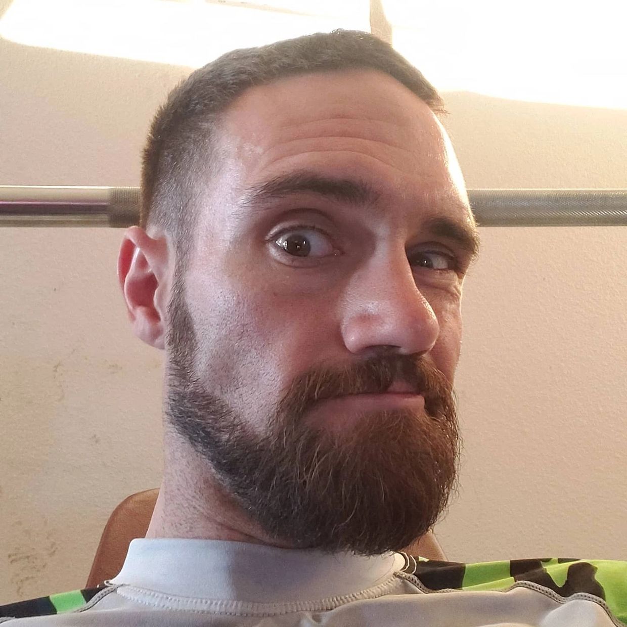 Close-up of a man with a beard and intense gaze.