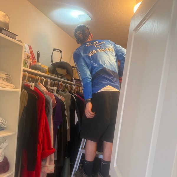 Person in closet fixing a light.