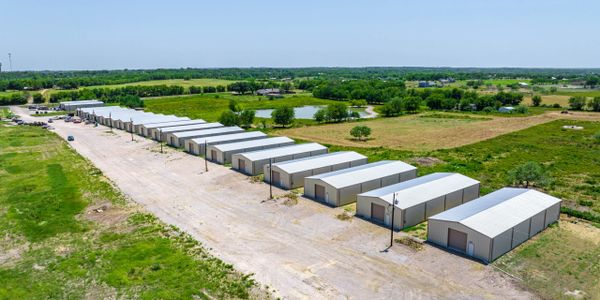 Aerial view of multiple storage units aligned in a rural area.