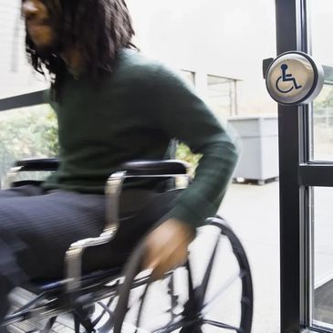 Man entering property via wheelchair upon use of an Automatic Door Operator